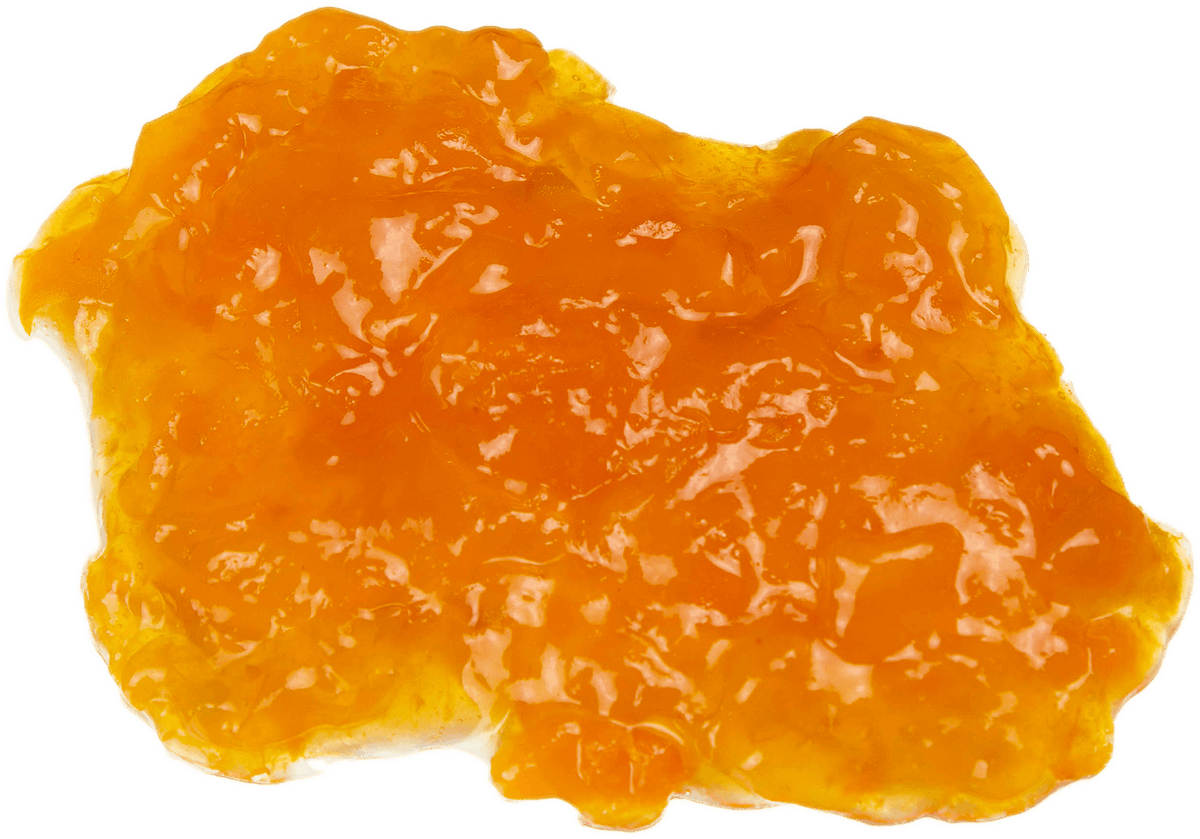 A glossy, translucent orange gel or jelly spread on a solid black background.