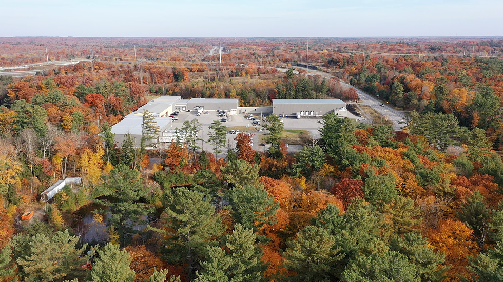 Aerial view of a large building surrounded by trees with autumn colors.